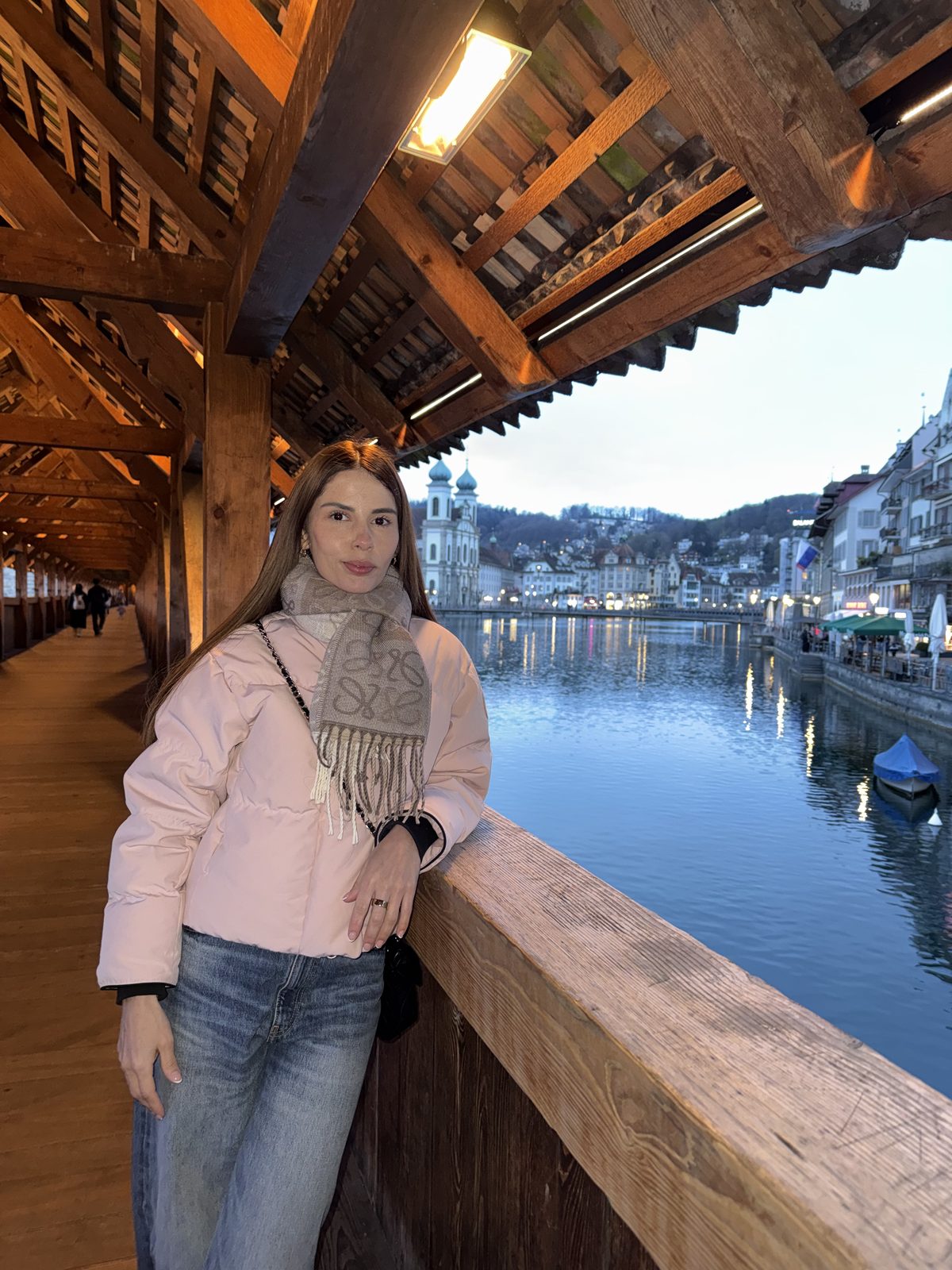 Isabella en un puente de madera cubierto junto a un lago