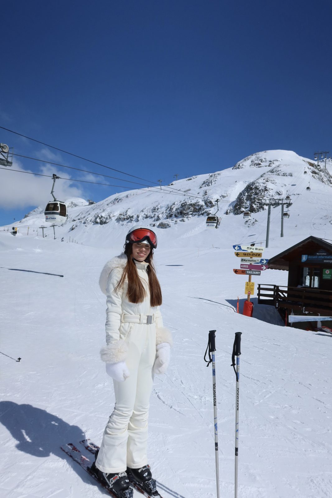 Isabella con traje de esquí blanco en la nieve